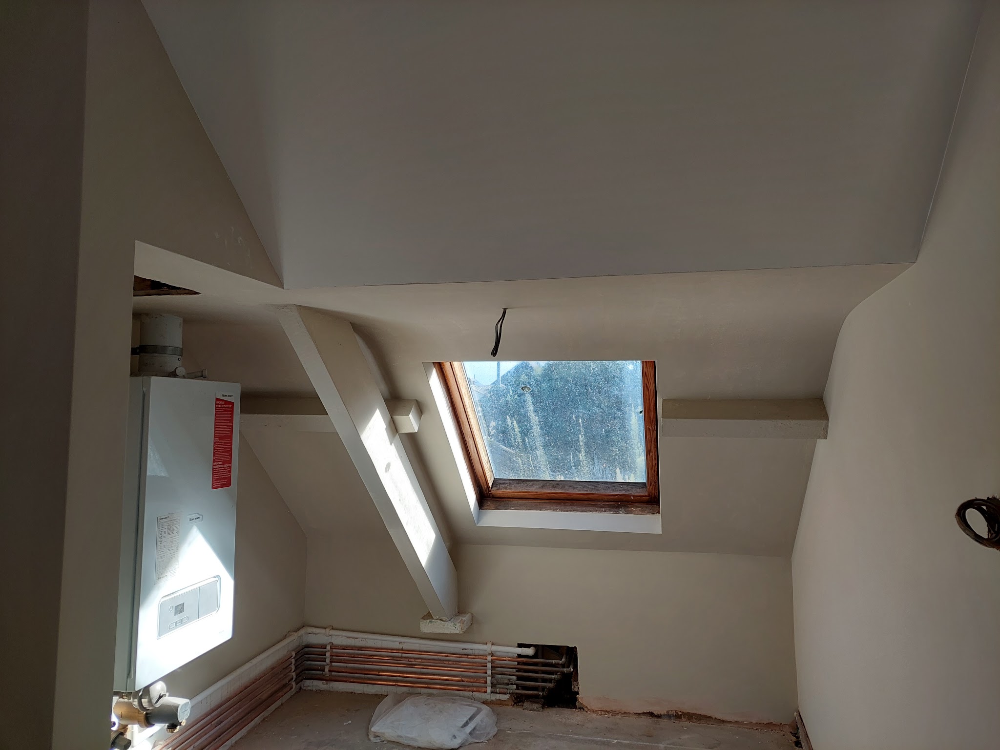 Loft room with sloping ceilings and a rooflight, walls finished and painted