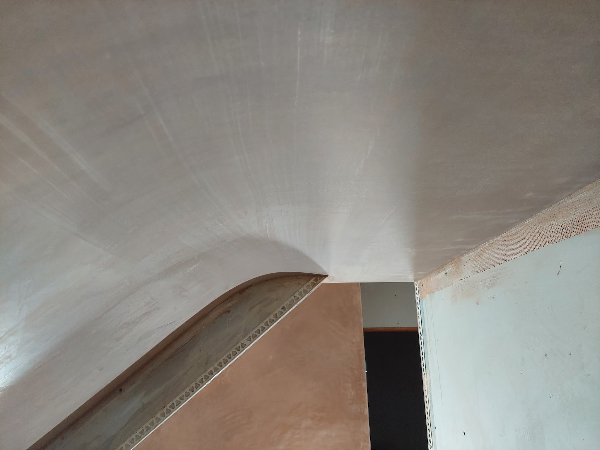 Freshly skimmed curved ceiling running into a stairwell opening