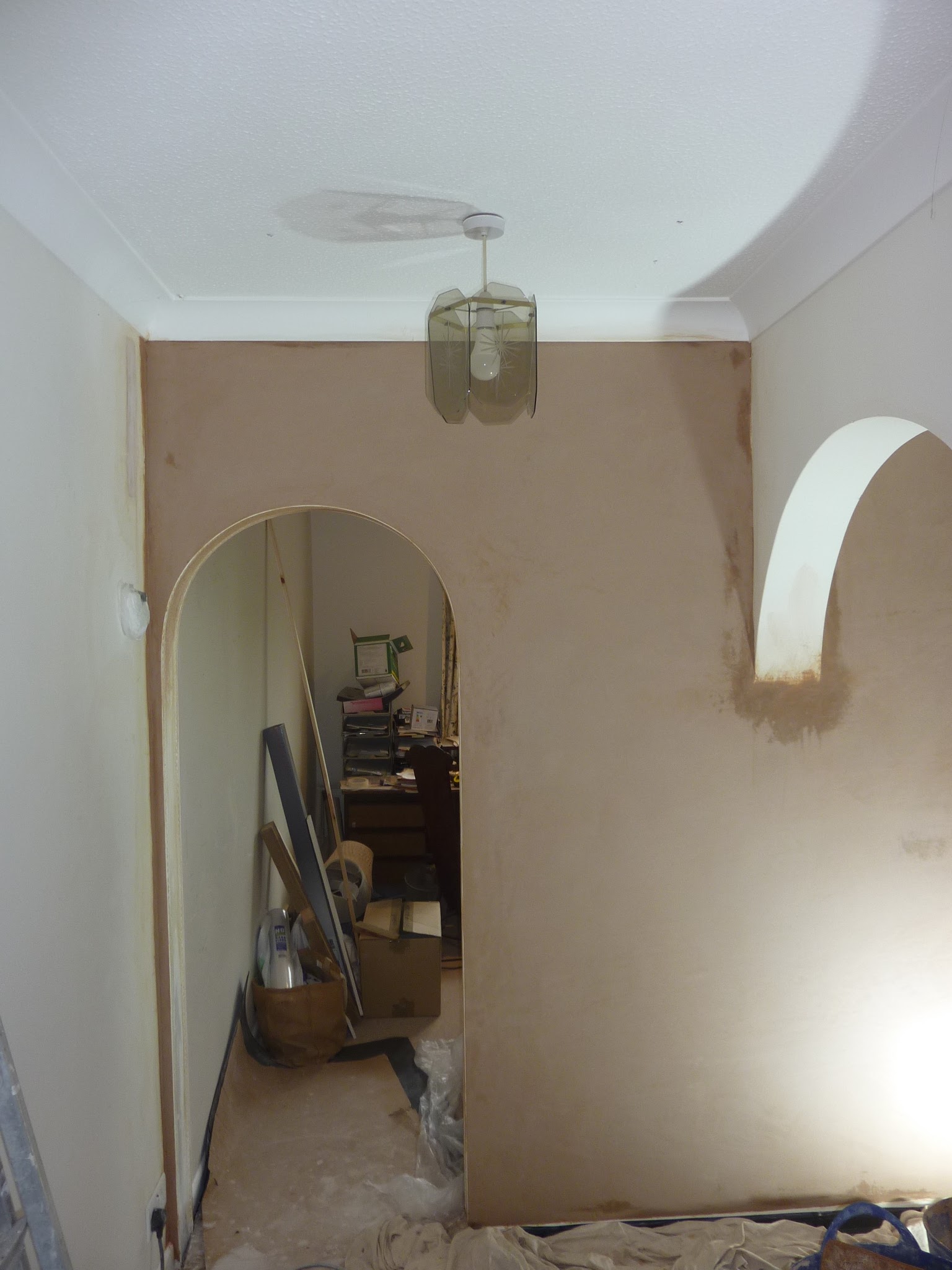 Hallway with a plastered arched doorway and a plastered arched alcove